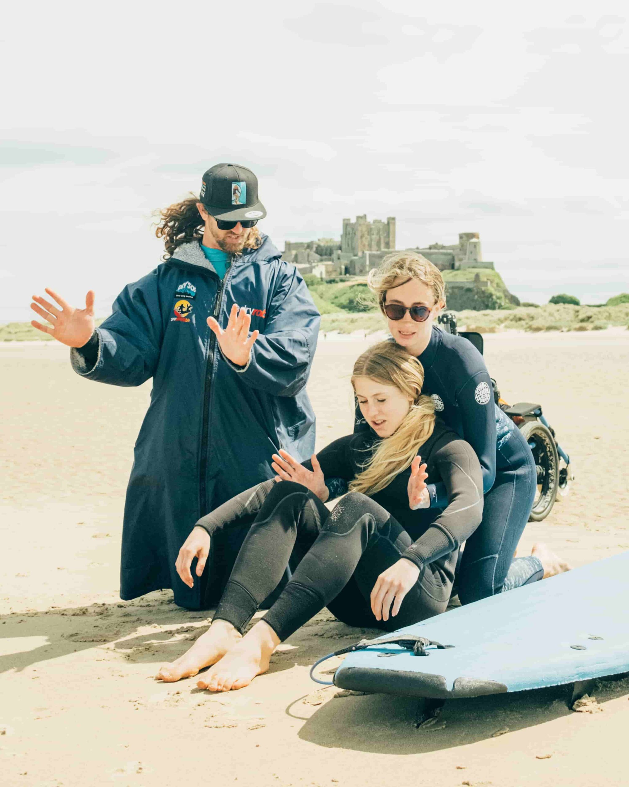 Adaptive surf instructor training in front of Bamburgh castle