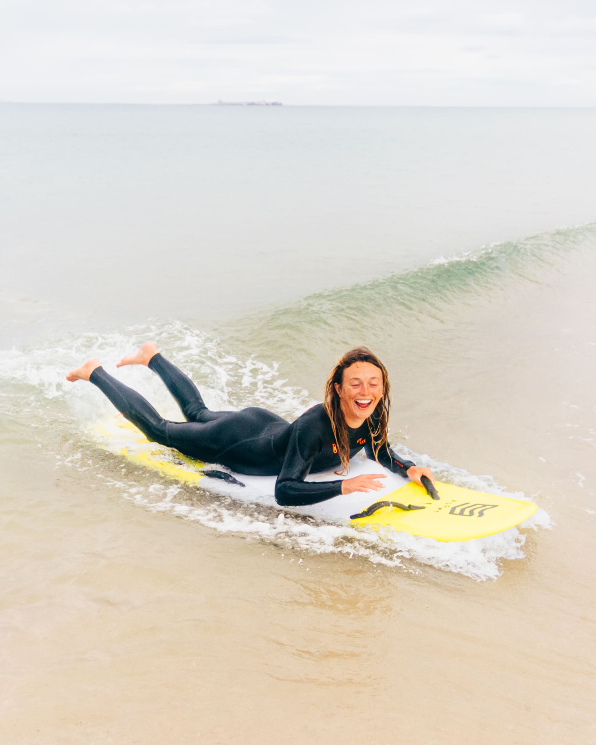 Emily of NE Surf rides a prone adapted surfboard