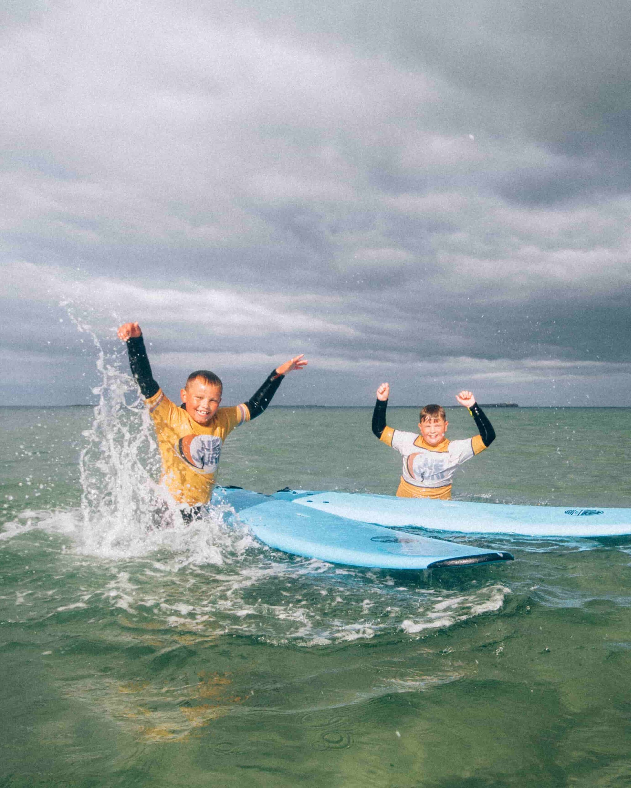 kids club surfers splashing the water